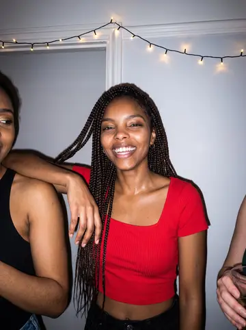 Nia, AI character: a December house party in Hyde Park, a string of lights over the doorway