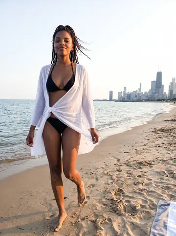 Nia, AI character: North Avenue Beach on Lake Michigan on a summer evening, the skyline behind