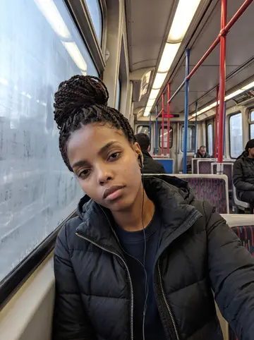 Nia, AI character: the Red Line train at dawn on her way north, the window foggy