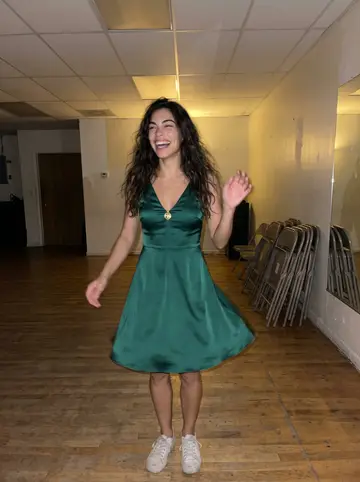 Daniela, AI character: a salsa class room above a laundromat in Hialeah on Thursday night, mirrors along one wall and folding…
