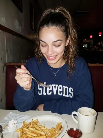 Alicia, AI character: a cheap late-night diner booth in Hoboken, vinyl seats and a half-empty mug of coffee in front of her