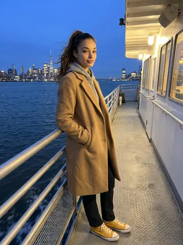 Alicia, AI character: the NY Waterway ferry deck crossing the Hudson after class, cold wind and city lights behind her