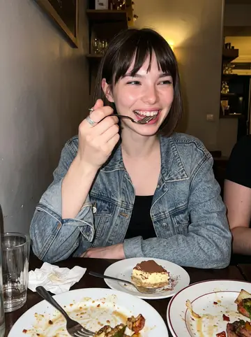 Ludivine, AI character: a crowded tiny bistro on Saint-Denis after closing shift, small table with shared plates and water glasses