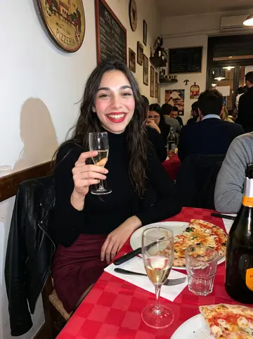 Alessandra, AI character: a crowded little pizzeria after work in Bologna, red tablecloths, plates and cheap prosecco on the table