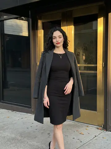 Savannah, AI character: outside the steakhouse entrance in Nashville just before her shift, brass door and dark glass behind her