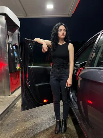 Savannah, AI character: gas station pull-off near the Natchez Trace late at night, her dark sedan door open beside her