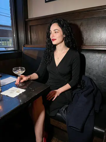 Savannah, AI character: dim booth at a downtown Nashville cocktail bar after a friend's birthday dinner
