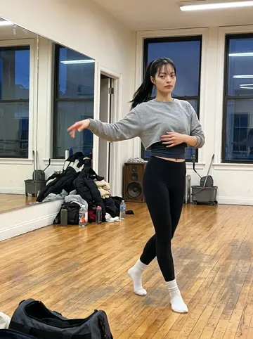 Claire, AI character: a dance practice room near Pike Place after Wednesday class, hardwood floor, mirrors along one wall,…