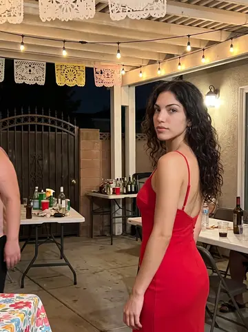 Valeria, AI character: Mateo's engagement party in her parents' Boyle Heights backyard on a warm night, string lights and papel…