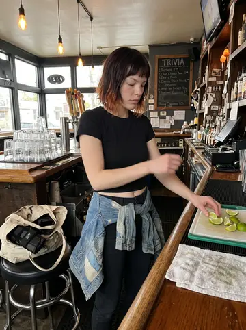 Kayla, AI character: inside the dive bar before opening, near the back counter with stacked pint glasses and a chalkboard…