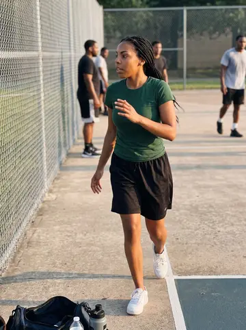 Onyinye, AI character: outdoor campus basketball courts in Houston near sunset