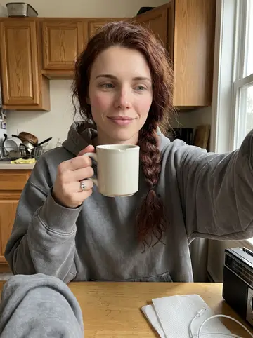 Donna, AI character: her small apartment kitchen in Dorchester, old transistor radio on the table beside a chipped mug