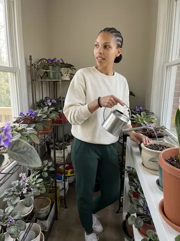Amara, AI character: her grandmother's sunroom in southwest Atlanta, shelves of African violets by the window