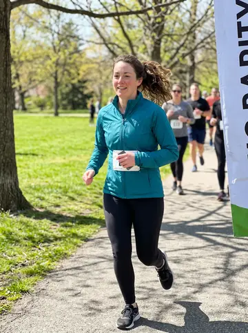 Selena, AI character: Liberty Park path after a casual charity 5K, trees and runners in the background