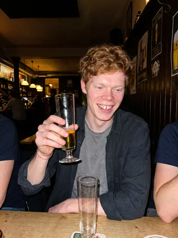 Patrick, AI character: small Kölsch pub near the arena after a late summer preseason game, teammates cropped around him