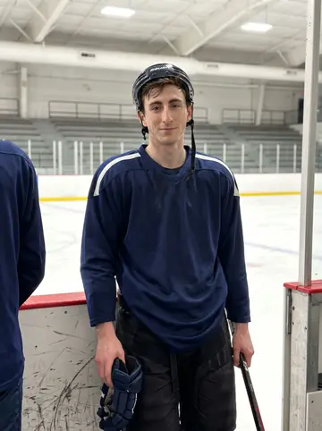 Conal, AI character: outside an arena service entrance in Boston after an evening skate, concrete wall and a strip of low city…