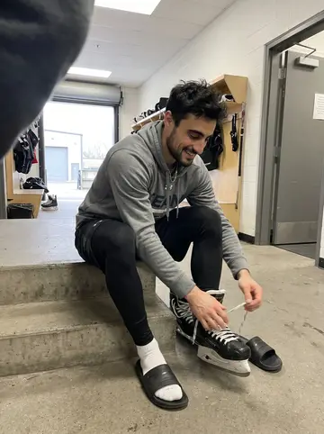 Modesto, AI character: inside the players' entrance hallway at the arena between practice and video review, concrete steps beside…