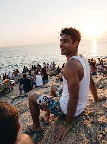 Thiago, AI character: Arpoador rock in Rio at sunset a few years ago, crowd clapping for the sun, the sea behind