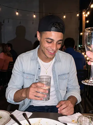 Alberto, AI character: a crowded late brunch that has turned into evening drinks on a humid patio in Toronto