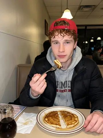 Francis, AI character: a late-night diner booth after a home game, laminated menu, syrup bottle, and pancake plate on the table