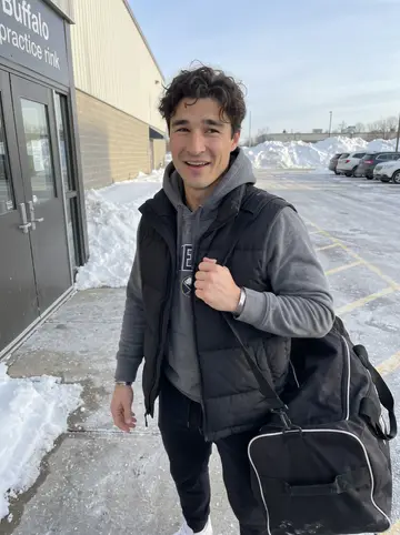 Evan, AI character: outside the Buffalo practice rink after morning skate, snowbanks by the parking lot and the rink doors…