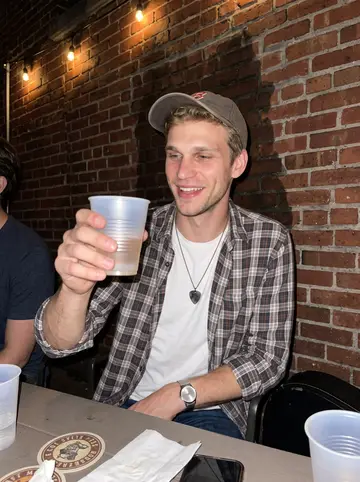 Andrew, AI character: narrow back patio behind the Broadway bar after his Wednesday set, bandmates cropped around the edges,…
