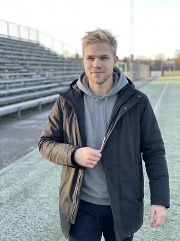 Bjørn, AI character: the edge of an outdoor football practice field in Minnesota after a cold morning workout, pale turf and…
