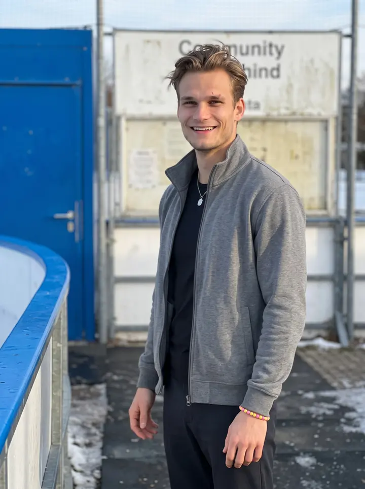 Tomasz, AI character: outside the community rink in southern Germany after Saturday practice, leaning on the blue rink boards…