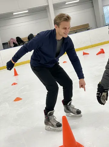 Tomasz, AI character: Saturday-morning learn-to-skate class at the community rink, little orange cones scattered across the ice