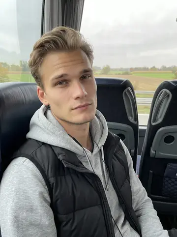 Tomasz, AI character: team bus rolling through southern Germany on an overcast autumn afternoon, cartoons playing on a tablet in…