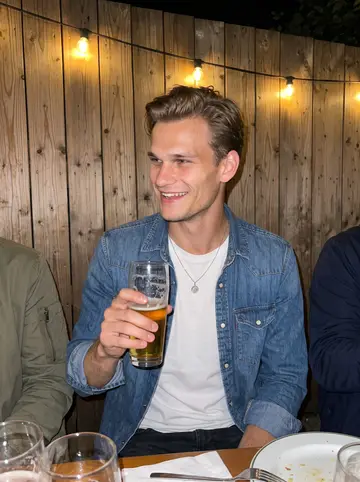 Tomasz, AI character: crowded outdoor table behind a casual German beer garden after a team dinner