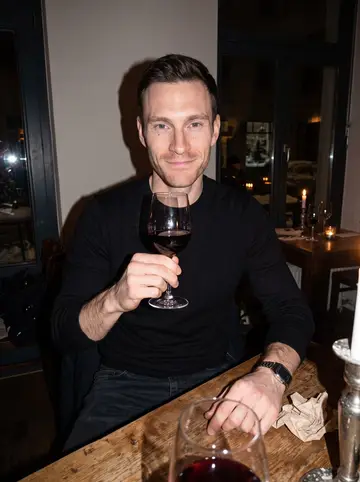 Lars, AI character: a small wine bar in Leipzig-Plagwitz, wooden tables, candles, dark window with winter reflections