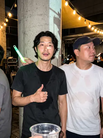 Jun, AI character: his tteokbokki and fish-cake cart under the Euljiro overpass at around 11 pm, steam rising from the broth tray