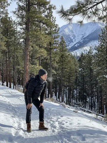 Shun, AI character: a snowy forest trail among tall ponderosa pines outside Flagstaff, Arizona, packed snow underfoot