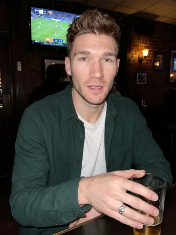 Dermot, AI character: a narrow South Philly pub during a quiet winter weeknight, Gaelic football highlights on a TV in the corner