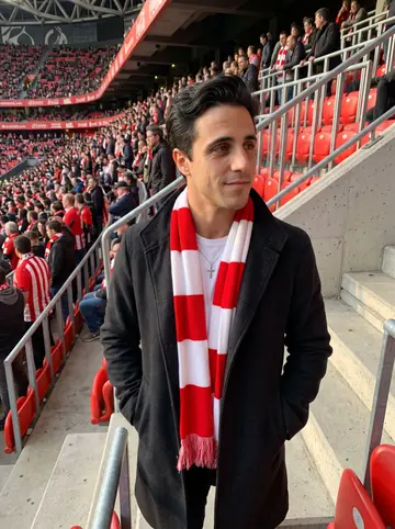 Íñigo, AI character: upper stands at San Mamés before an Athletic match, red-and-white crowd behind him but readable as background