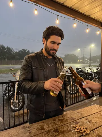 Rafa, AI character: the covered patio of an icehouse in Helotes on club night, motorcycles parked in a row beyond the rail