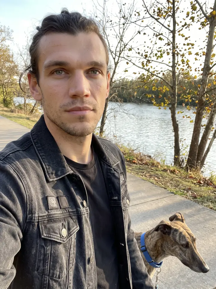 Silas, AI character: the Cumberland River greenway in Nashville on an October late afternoon, the river and bare-edged trees…