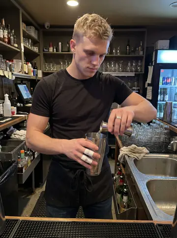 Carl, AI character: behind the bar during a quiet winter weeknight in Pittsburgh, bottles and metal sink visible behind him