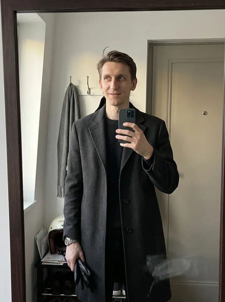 Aleksei, AI character: an empty stretch of the Ringstrasse in Vienna at early morning, he sits on his small cream-coloured…