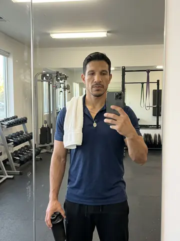 Ramon, AI character: the gym parking lot in San Bernardino at the end of the afternoon, leaning on the open door of his old…