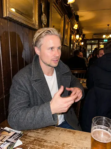 Ivar, AI character: a crowded old pub in the Haga district of Gothenburg on a winter night, dark wood walls and a pint on the…