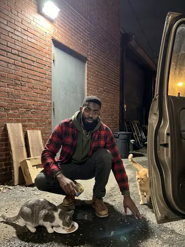 Terrence, AI character: a downtown Detroit sidewalk outside a renovated hotel entrance with brass doors and warm lobby light,…