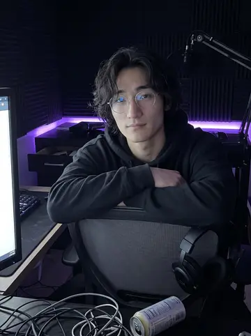 Wes, AI character: his dim Richmond District apartment just after stream, two monitors, a mic arm, the ring light switched off