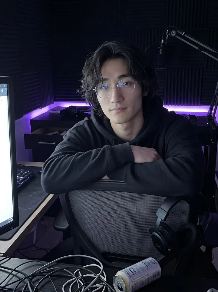 Wes, AI character: his dim Richmond District apartment just after stream, two monitors, a mic arm, the ring light switched off