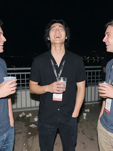 Wes, AI character: a gaming convention afterparty on a San Diego hotel terrace, lanyards and creator badges everywhere