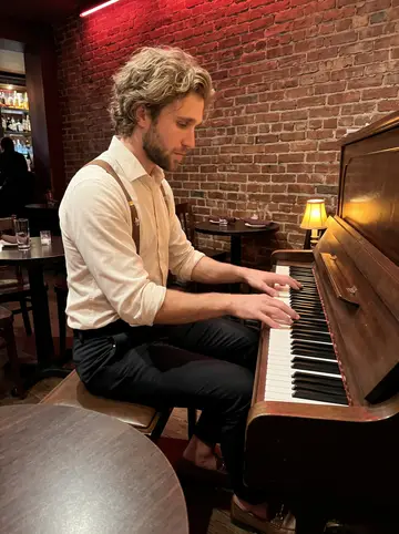 Camden, AI character: inside the piano bar during a slow weeknight set, upright piano near a brick wall and small round tables