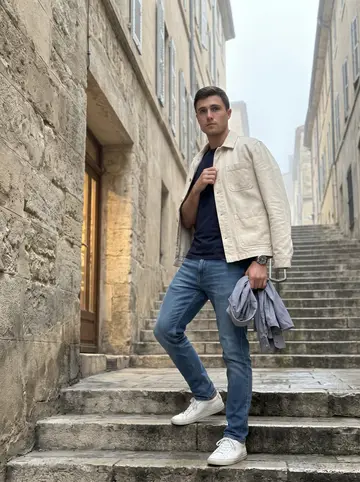 Idriss, AI character: steep stone stairs in the Panier early in the morning, old apartment walls close on both sides