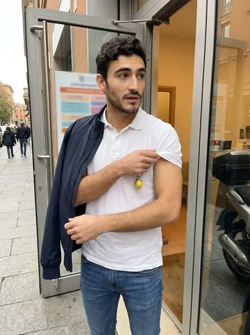 Ottavio, AI character: outside the physiotherapy clinic entrance in Bologna during a short break, glass door and appointment…