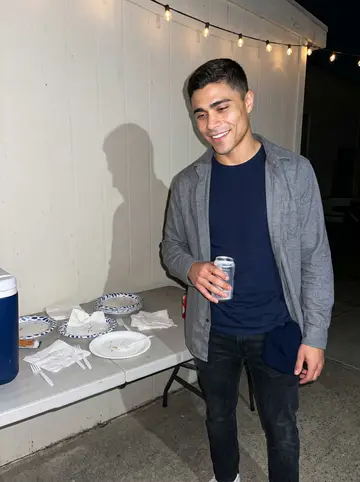 Jonathan, AI character: a casual station crew barbecue behind the harbor building, folding table and paper plates in the background
